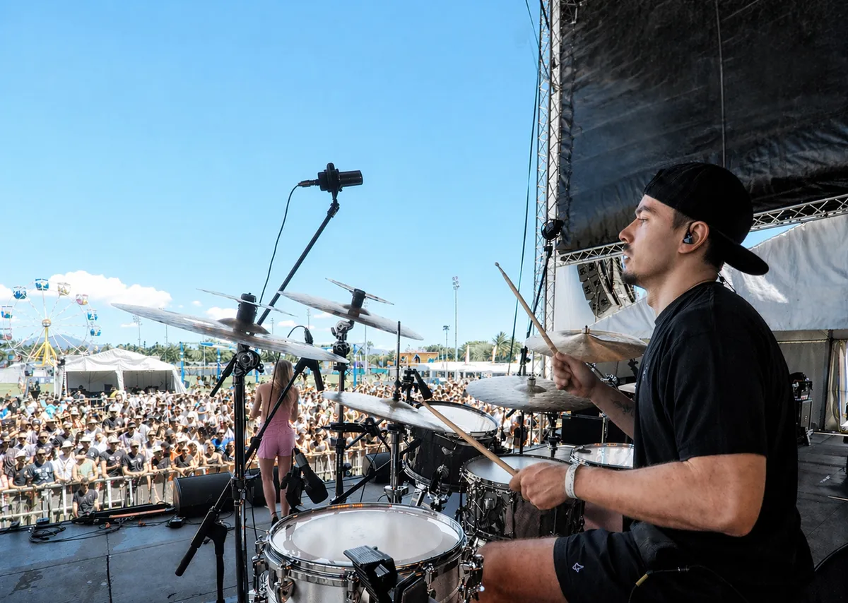 Dave performing on drums on stage at an outdoor festival