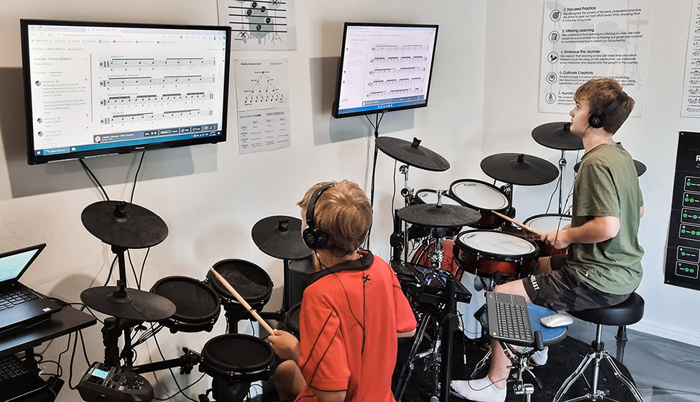 Students practising on electronic drum kits in the teaching studio